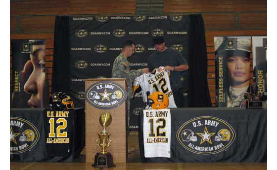 U.S. Army Sgt. Gene Burgess, stationed in Oceanside, presents Magnuson with a jersey.